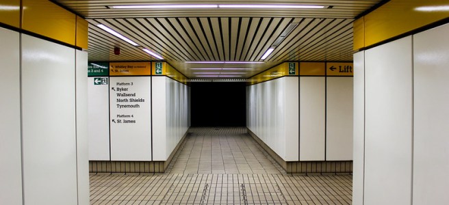 Image of the inside of the Monument Metro station in Newcastle with it's classic yellow edging and white walls.